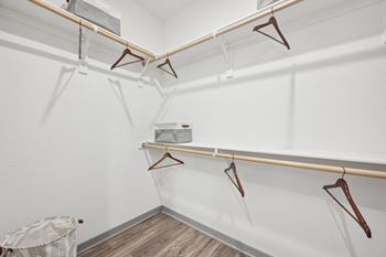 a white closet with hangers on the wall and a basket on the floor at The Garrison Luxury Apartment Homes, Fountain